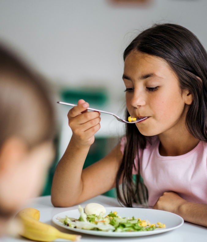 Fille qui mange Cantine pour tous